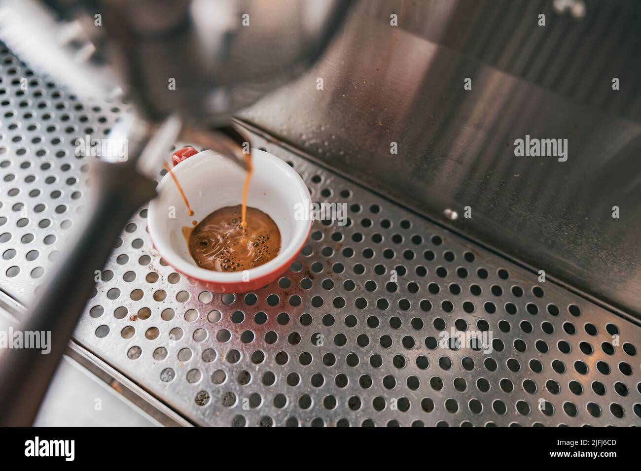 Vista ravvicinata della preparazione del caffè espresso in una macchina da caffè automatica nel caffè Foto Stock