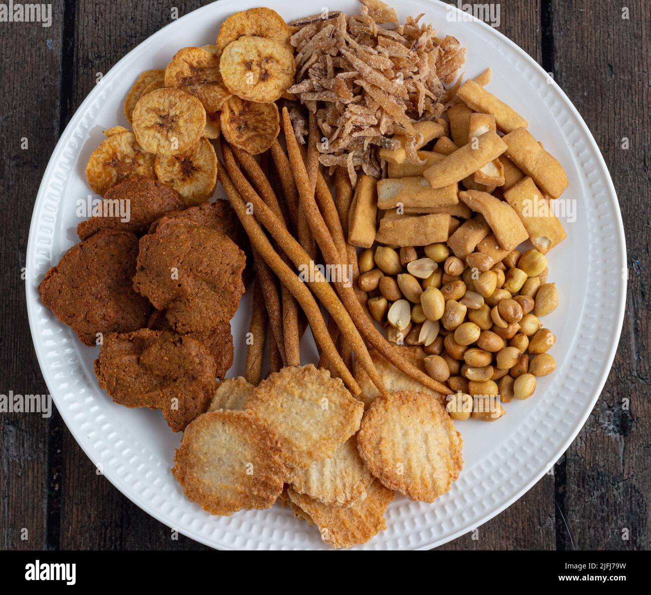 Una selezione di spuntini nigeriani - patatine, arachidi, kokoro, gurundi, mento, caramelle al cocco, kulikuli Foto Stock