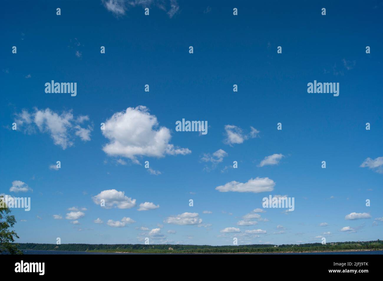 Profonda e fredda ryokana nel nord della Russia. Le stagioni sono estate. Una spiaggia di sabbia con cespugli verdi che crescono su di essa. Nuvole bianche nel cielo blu Foto Stock