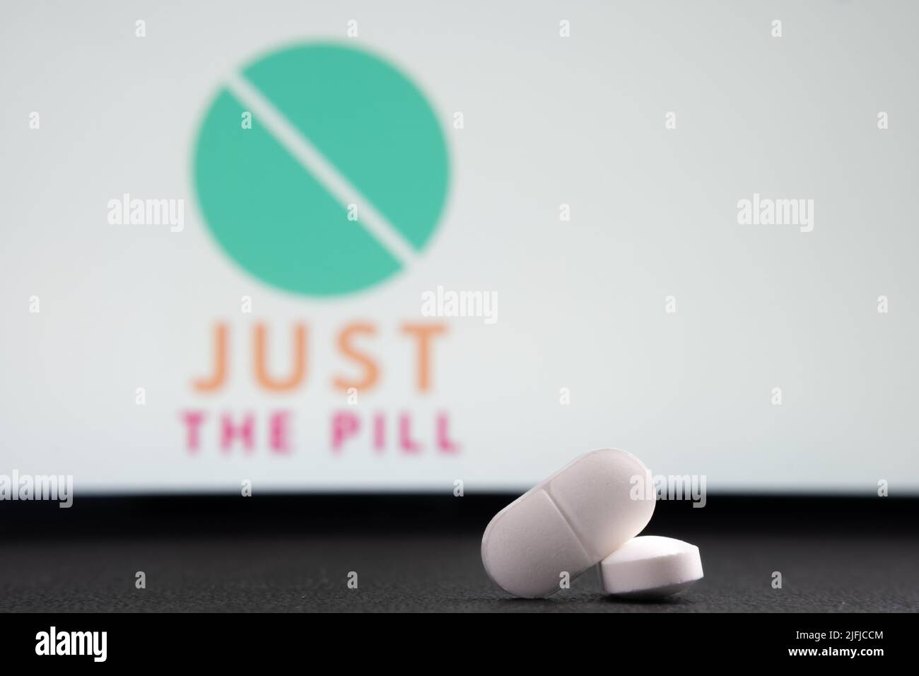 Pillole bianche e SOLO IL logo DELLA PILLOLA azienda su uno sfondo sfocato. Concetto per la piattaforma online di aborto telesanità. Stafford, Regno Unito, luglio 3, Foto Stock