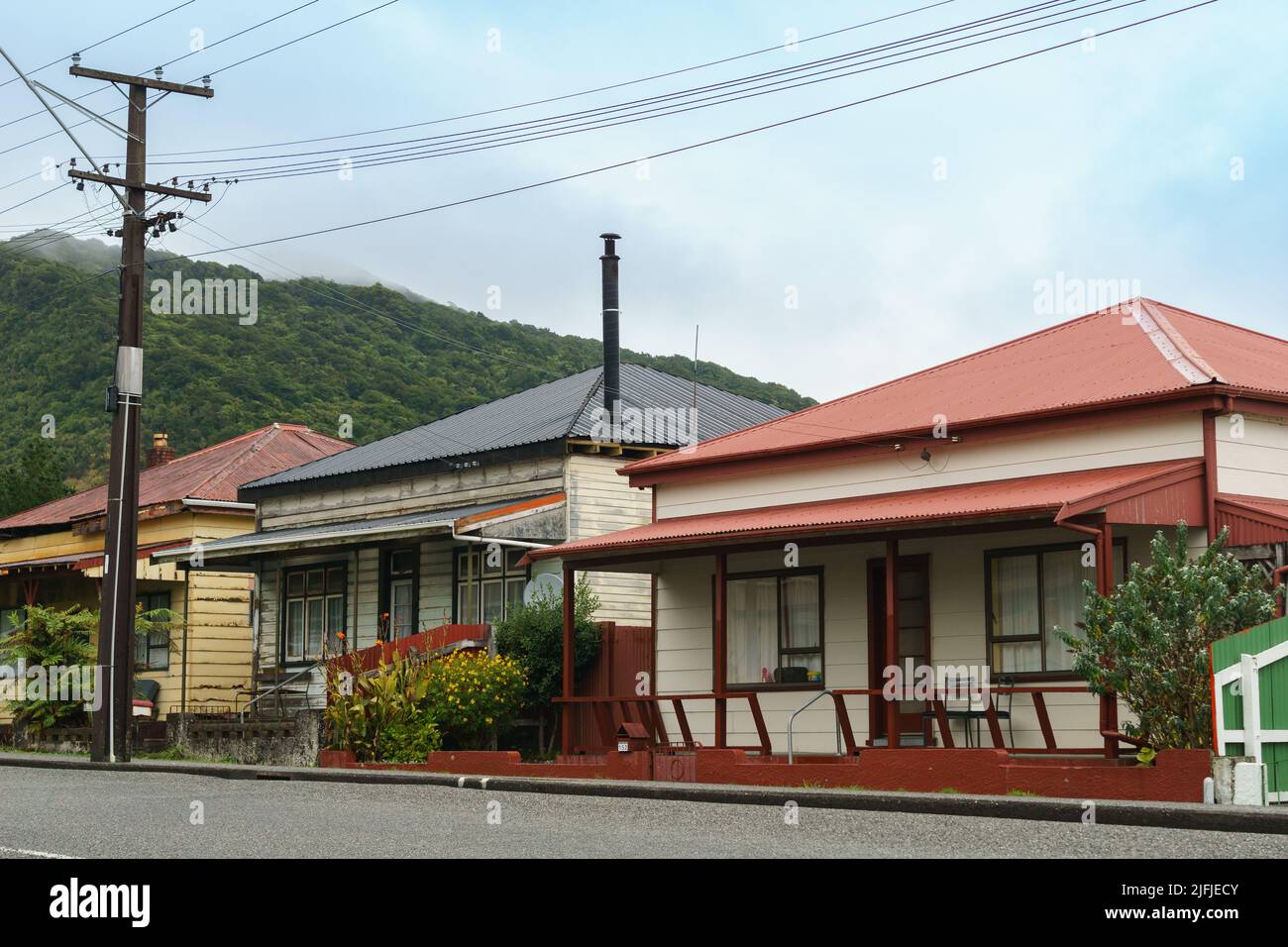 Vista sulla strada di case in stile antico patrimonio con veranda e ingresso sulla strada a Cobden Greymouth, Nuova zelanda. Foto Stock