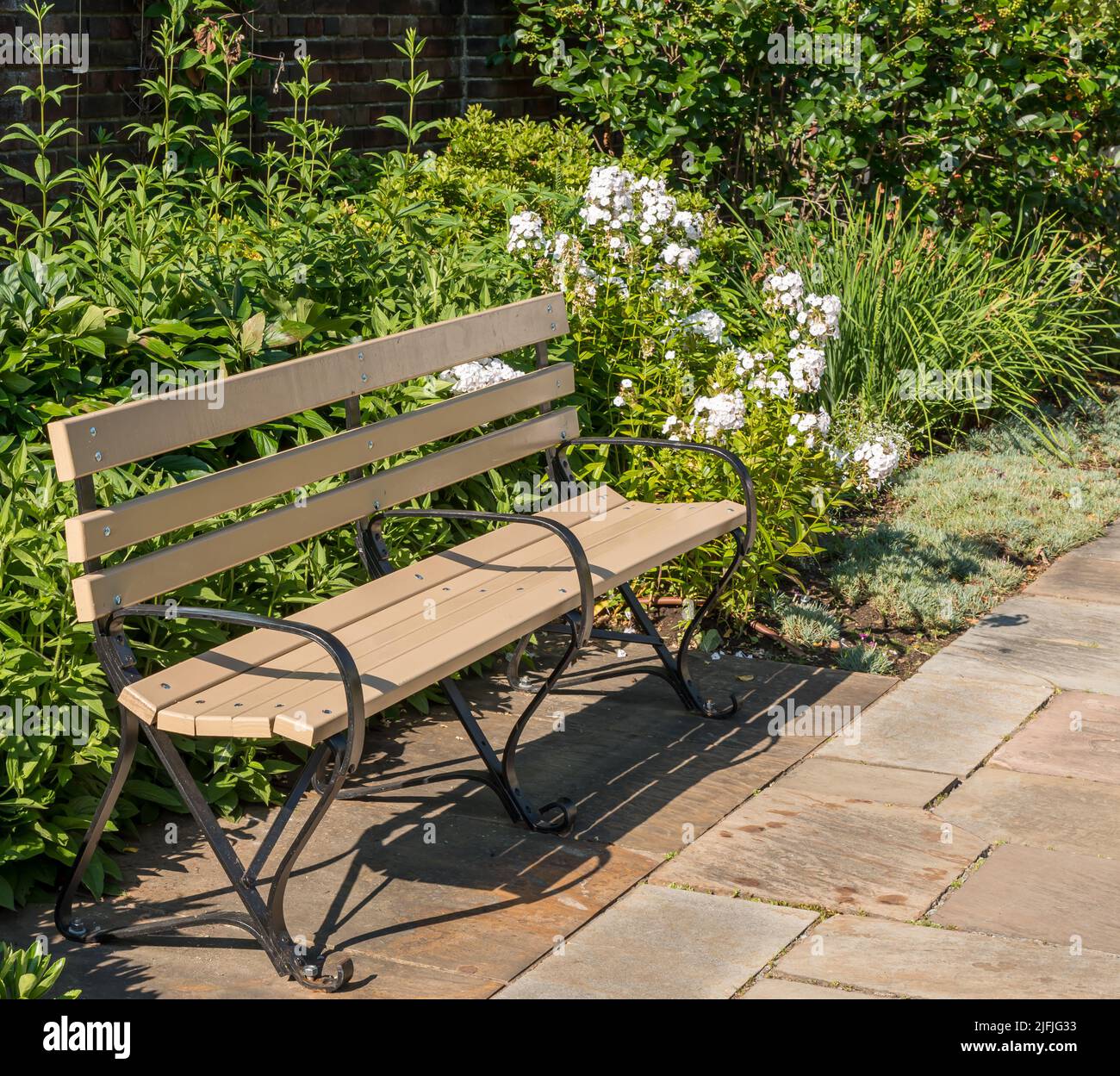 Una panca di legno in un giardino di fiori in città di proprietà Mellon Park a Pittsburgh, Pennsylvania, Stati Uniti d'America in una giornata estiva soleggiata Foto Stock