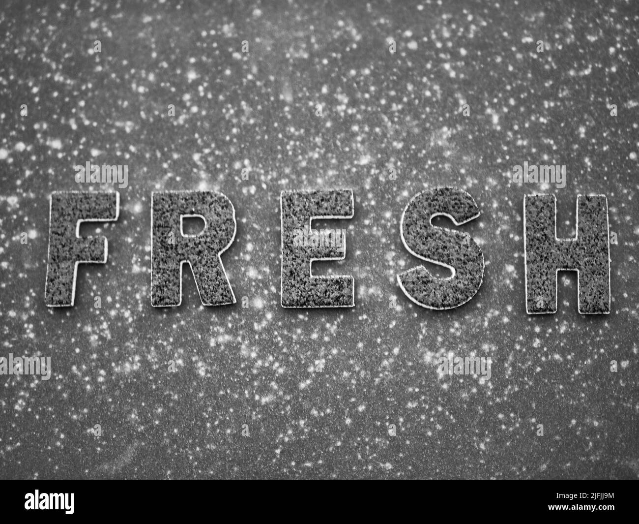 La parola 'Fresh' in lettere nere su una superficie di metallo arrugginito nero. Foto Stock