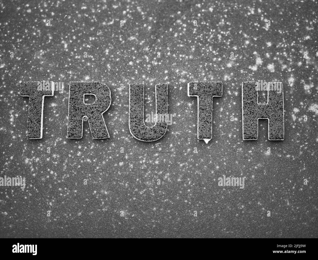 La parola 'verità' in lettere nere su una superficie di metallo arrugginita nera. Foto Stock