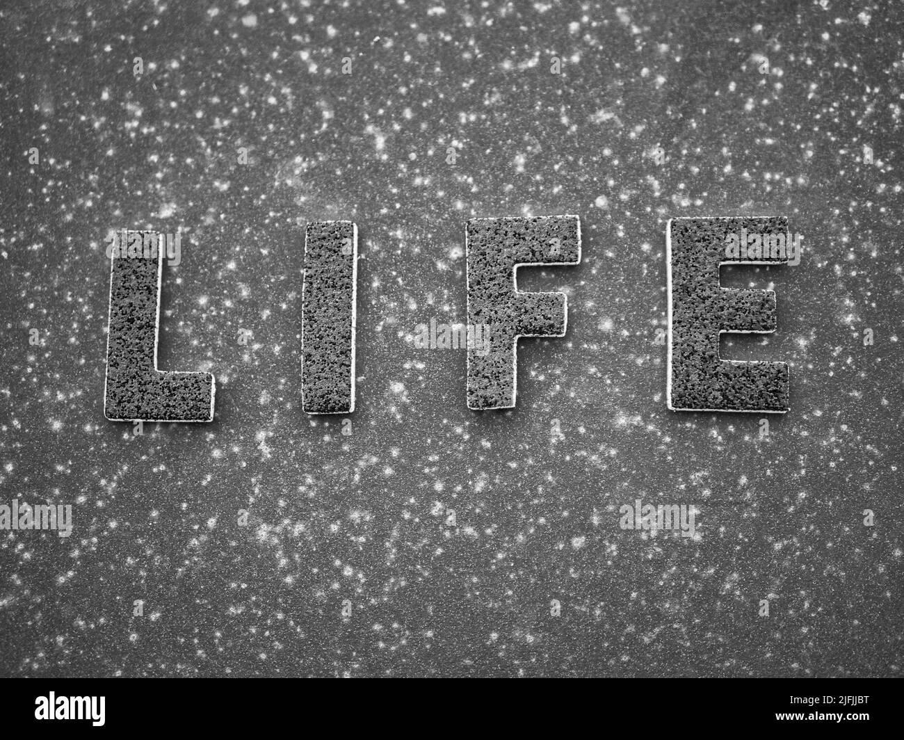 La parola 'vita' in lettere nere su una superficie di metallo arrugginito nero. Foto Stock