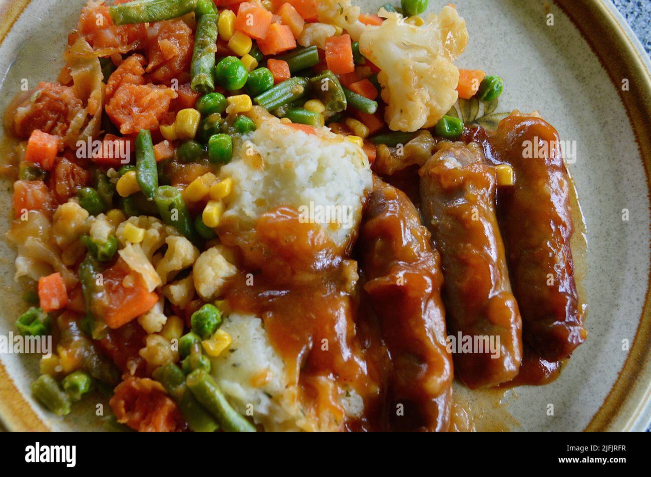 Salsicce con sugo di cipolla e verdure Foto Stock