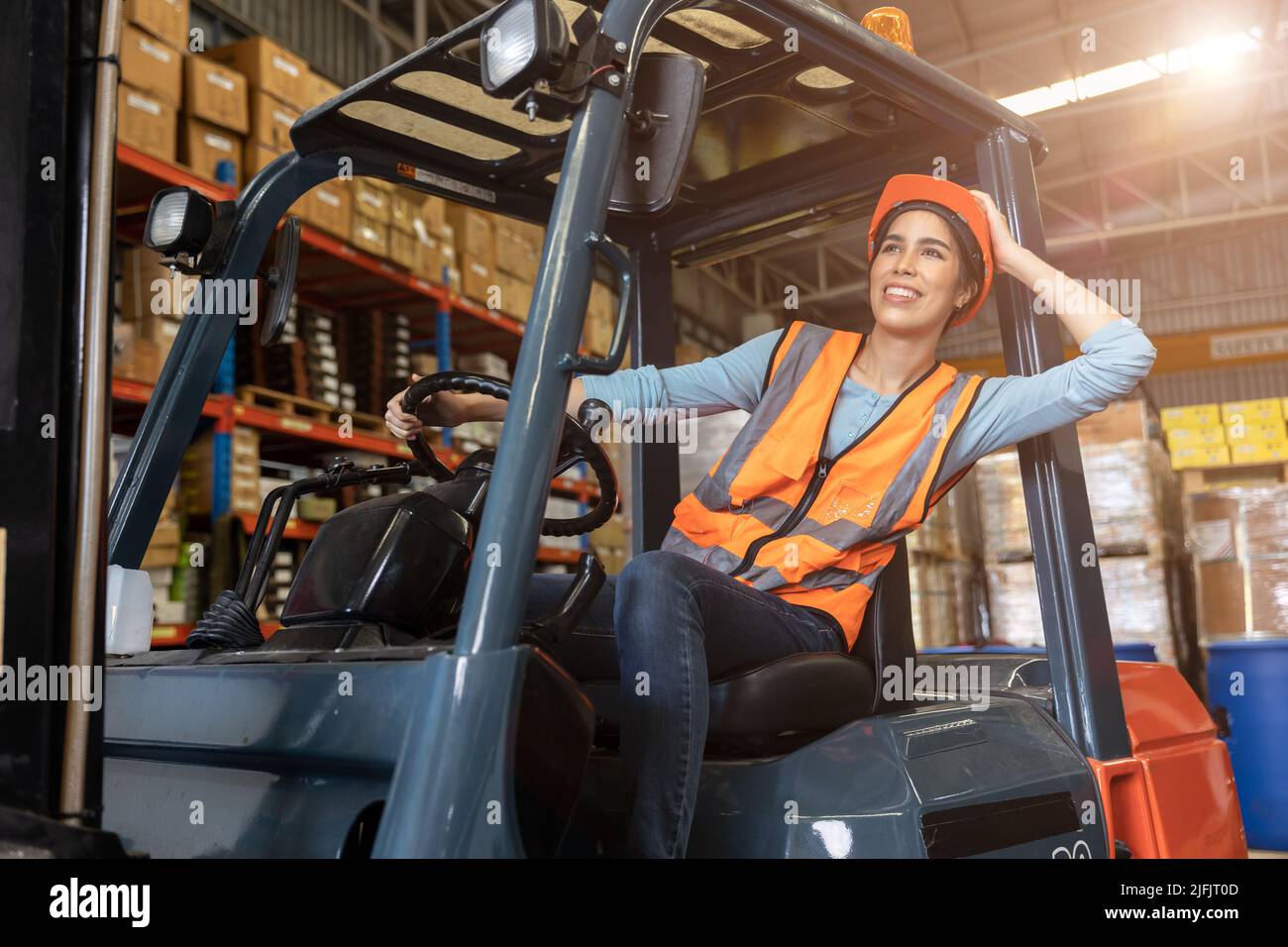 Felice donna lavoratore magazzino personale carrello elevatore a forche conducente felice sorridente godere di lavoro persone asiatiche. Foto Stock