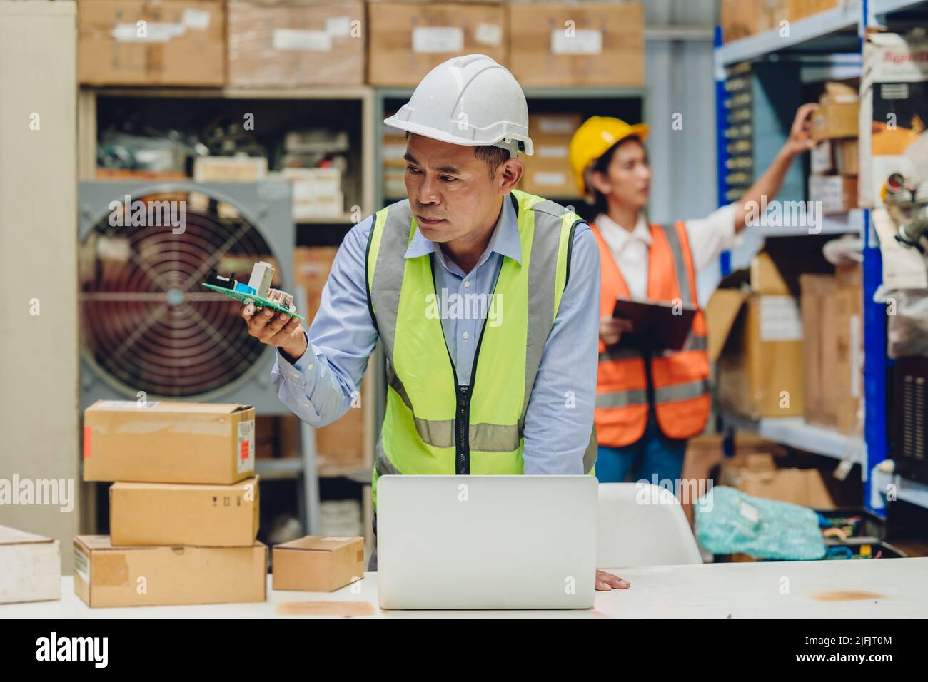 Un tecnico senior verifica la qualità e le specifiche dei pezzi di ricambio ricevuti dal concessionario prima della raccolta in magazzino. Foto Stock