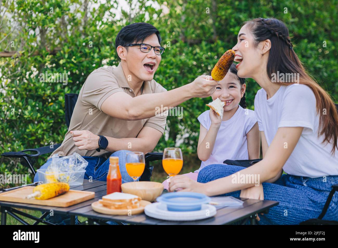 Attività in famiglia insieme picnic con barbecue grigliate pasto nel parco all'aperto cortile casa con i bambini Foto Stock