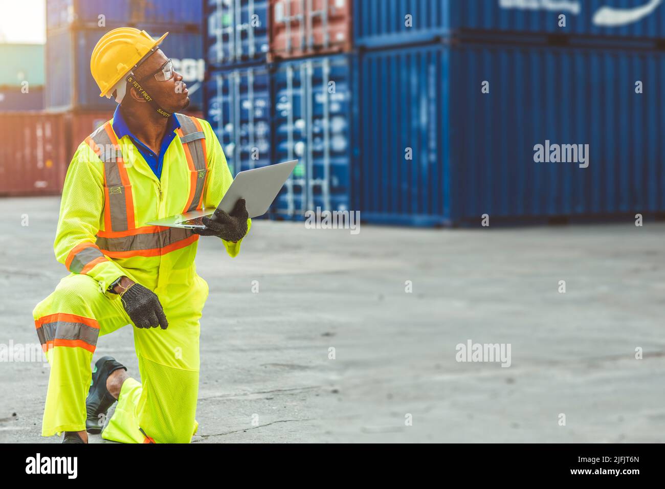 Foreman Containers Cargo Control Caricando il personale con computer portatile nero lavoratore uomo lavoro in porto cantiere spedizione. Foto Stock