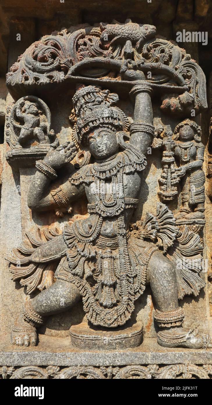 Scultura di Arjuna sparando un pesce di legno vedendo la sua riflessione in una ciotola di olio, Tempio di Chennakeshava, Aralguppe, Tumkur, Karnataka, India. Foto Stock