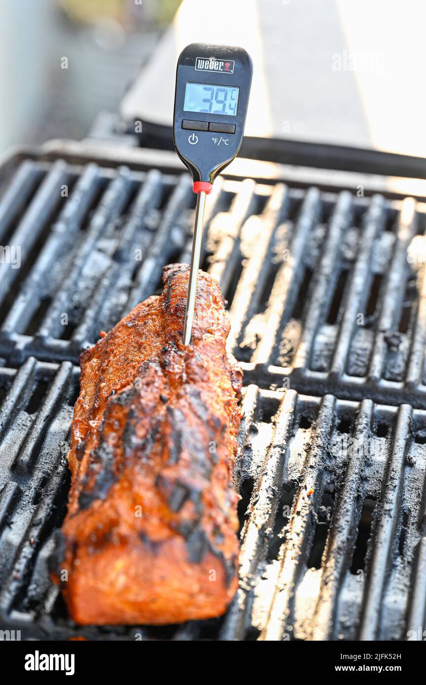 Termometro di carne con filetto di maiale sulla griglia Foto Stock