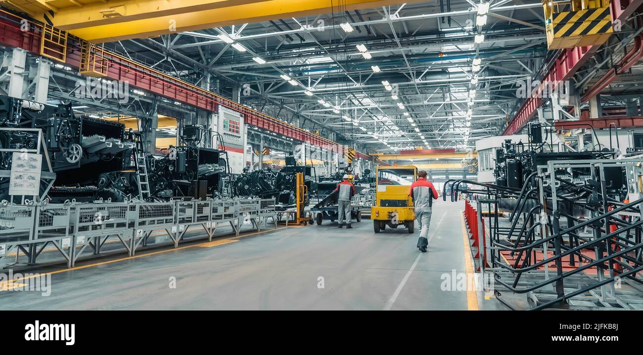 Grande fabbrica industriale. Produzione di macchine agricole. Lavoratori e attrezzature tecniche in officina. Foto Stock