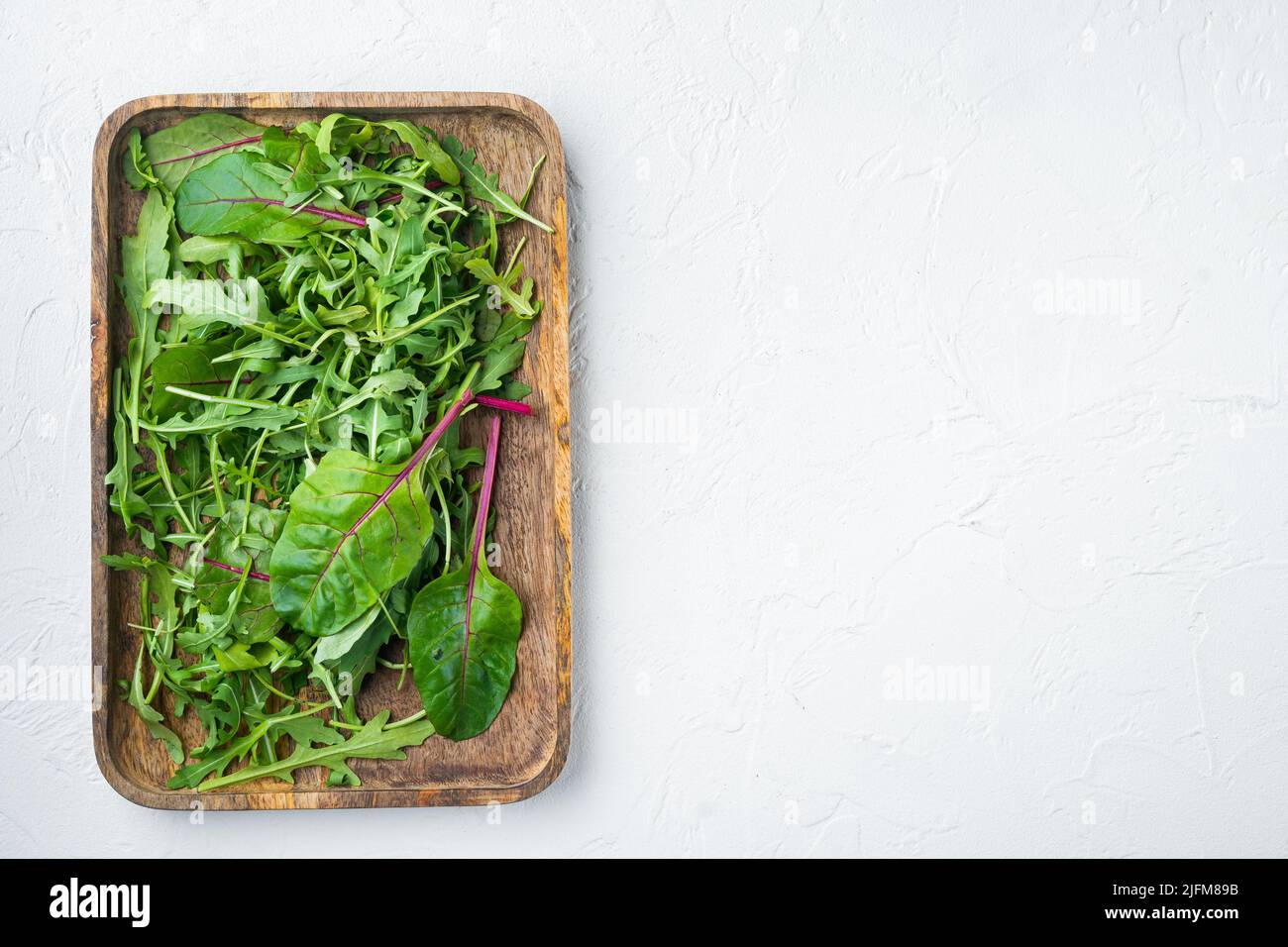 Rucola raab e Mangold, set di bietole svizzere, su sfondo di pietra bianca, vista dall'alto, con spazio per la copia del testo Foto Stock