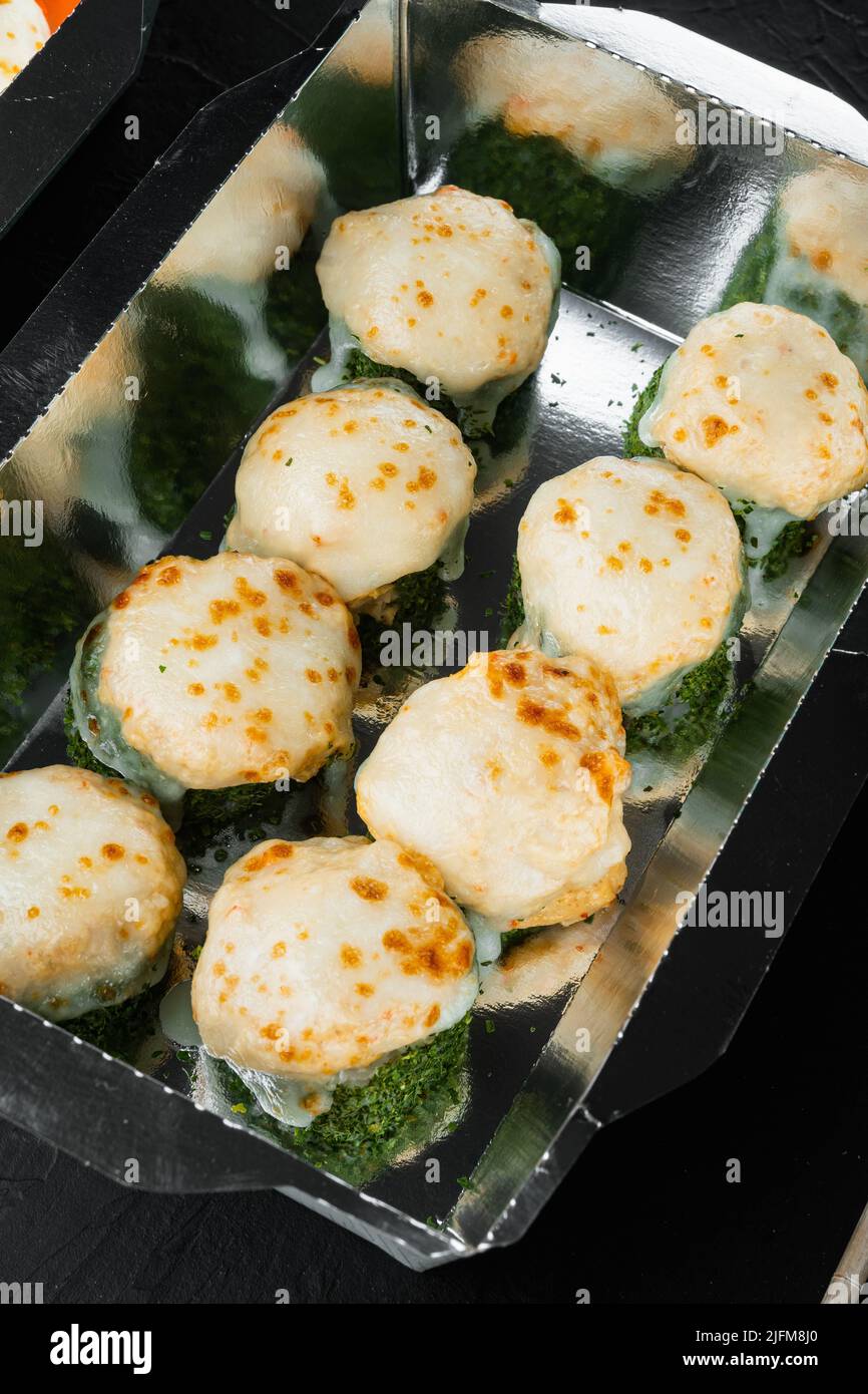 Sushi roll in contenitore da asporto, su sfondo in pietra nera Foto Stock