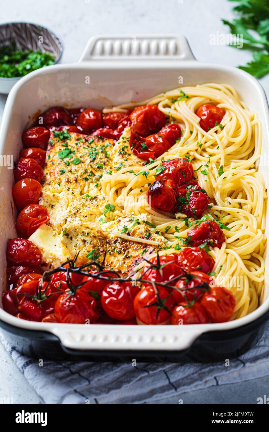 Feta al forno con pomodoro e spaghetti in un piatto. Ricetta casereccia alla moda. Foto Stock
