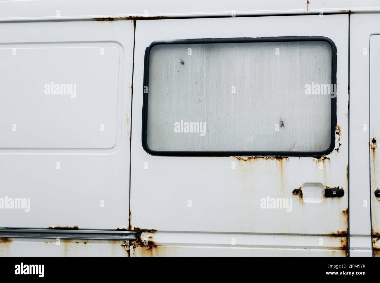 Bianco arrugginito abbandonato furgone compatto. Vecchia grunge auto Foto Stock