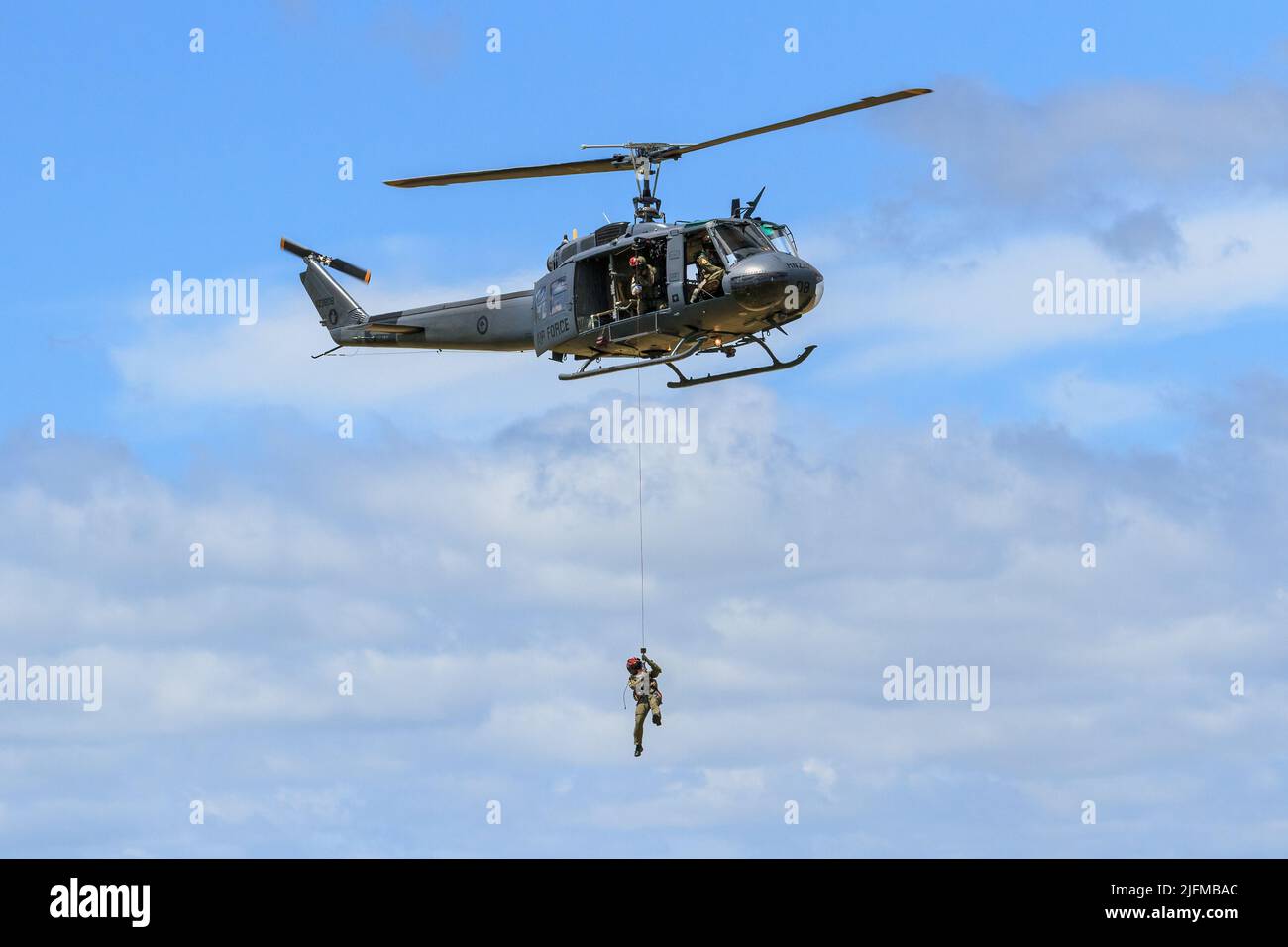 Un elicottero Bell UH-1 Iroquois 'Huey' della Royal New Zealand Air Force, abbassando un uomo su una corda Foto Stock