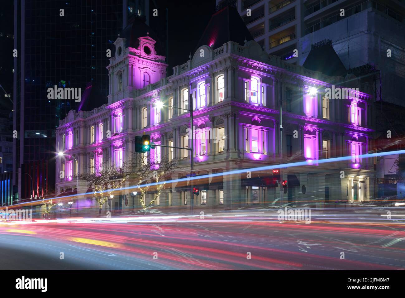 Il vecchio edificio Customhouse del 1880s ad Auckland, Nuova Zelanda, si illuminerà di notte. I sentieri per auto passano su Customs Street Foto Stock