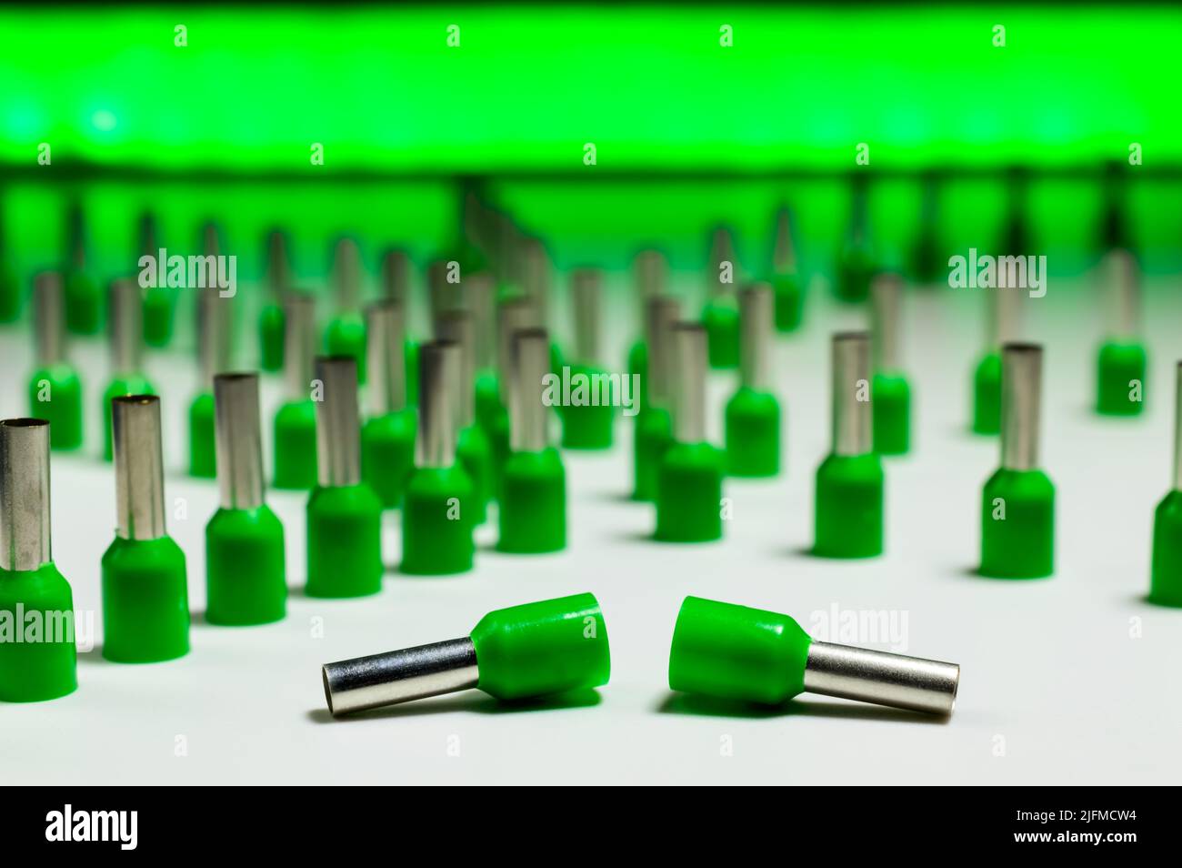 Ghiere verdi su sfondo bianco unite in una compilation astratta con un tubo verde dietro, che sta dando la retroilluminazione. Messa a fuoco selettiva. Foto Stock