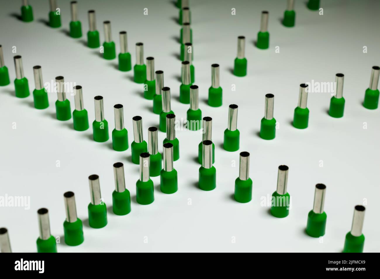 Ghiere verdi su sfondo bianco unite in una compilation astratta con un tubo verde dietro, che sta dando la retroilluminazione. Messa a fuoco selettiva. Foto Stock