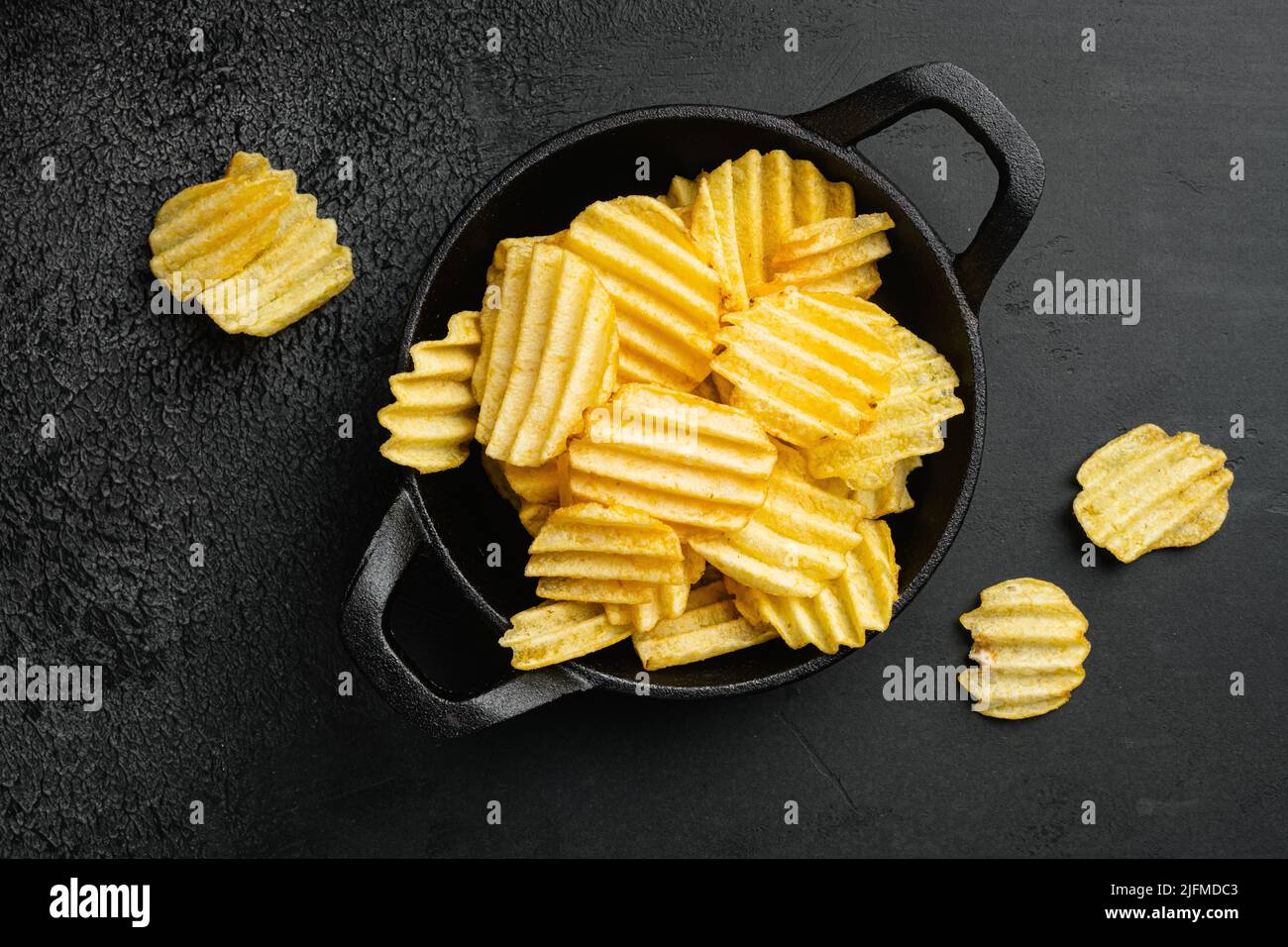 Wavy Ranch Flavored patata chips su sfondo nero tavolo di pietra scura, vista dall'alto piatto lay Foto Stock