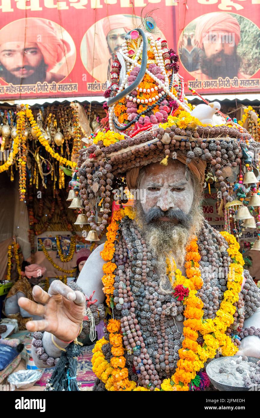 Sadhu ricoperto di cenere bianca con un cappello decorato con collane e perle di ghirlane Marigold, per uso editoriale, Allahabad Kumbh Mela, la più grande del mondo Foto Stock