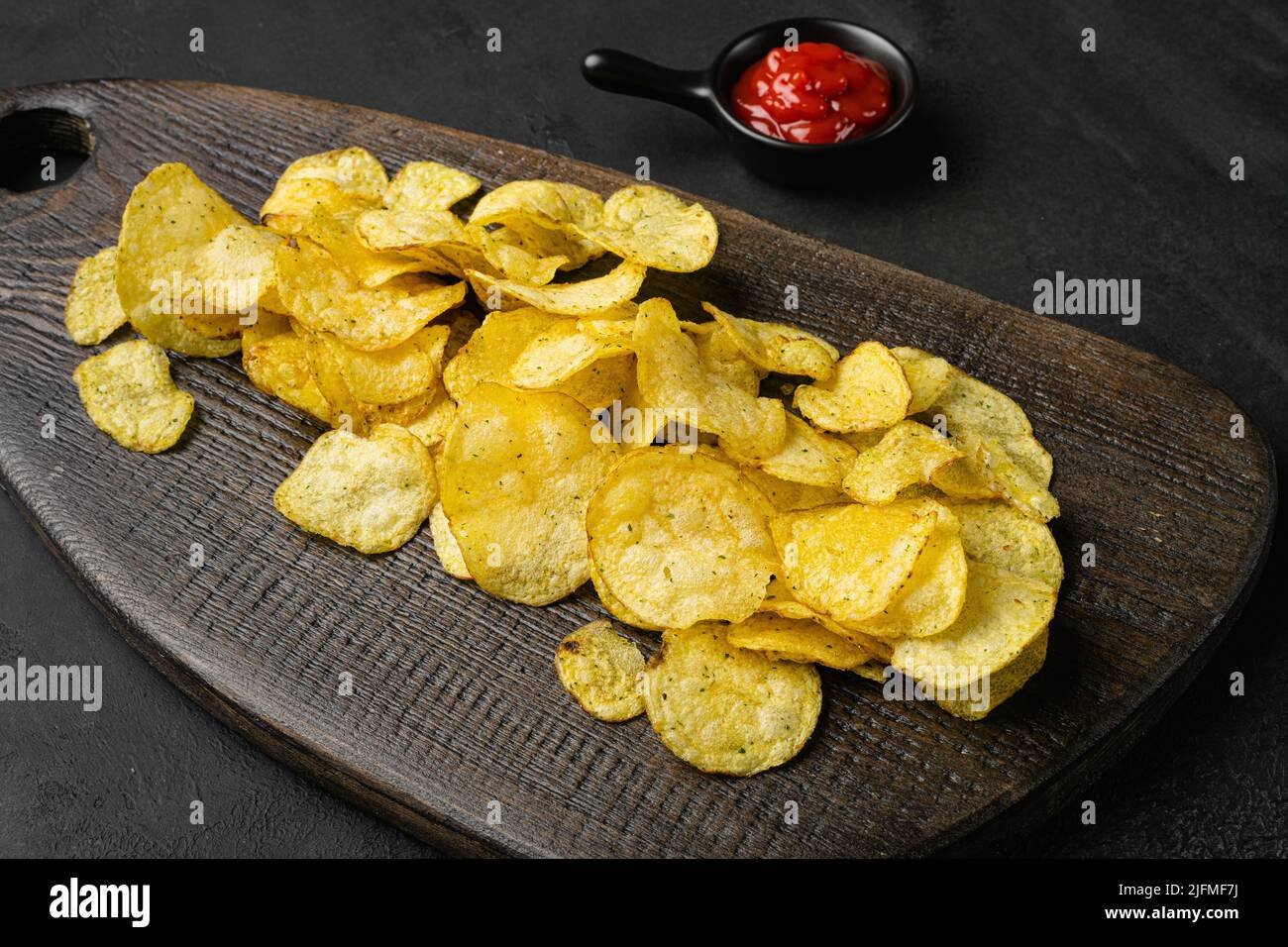 Patatine croccanti su sfondo nero di pietra scuro tavolo Foto Stock