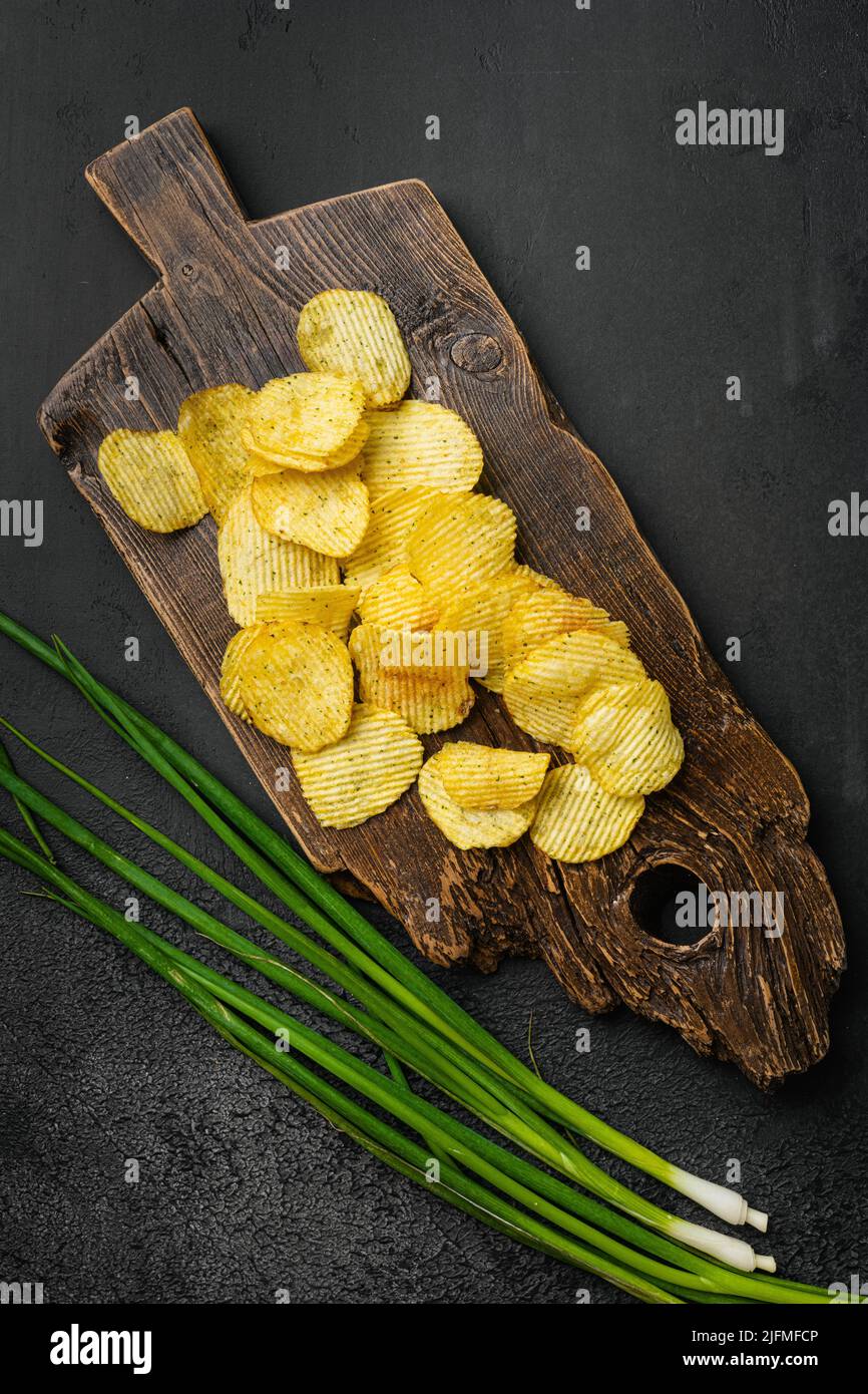 Ondulato ridotto grasso chip su sfondo nero pietra scura tavolo, vista dall'alto piatto Foto Stock