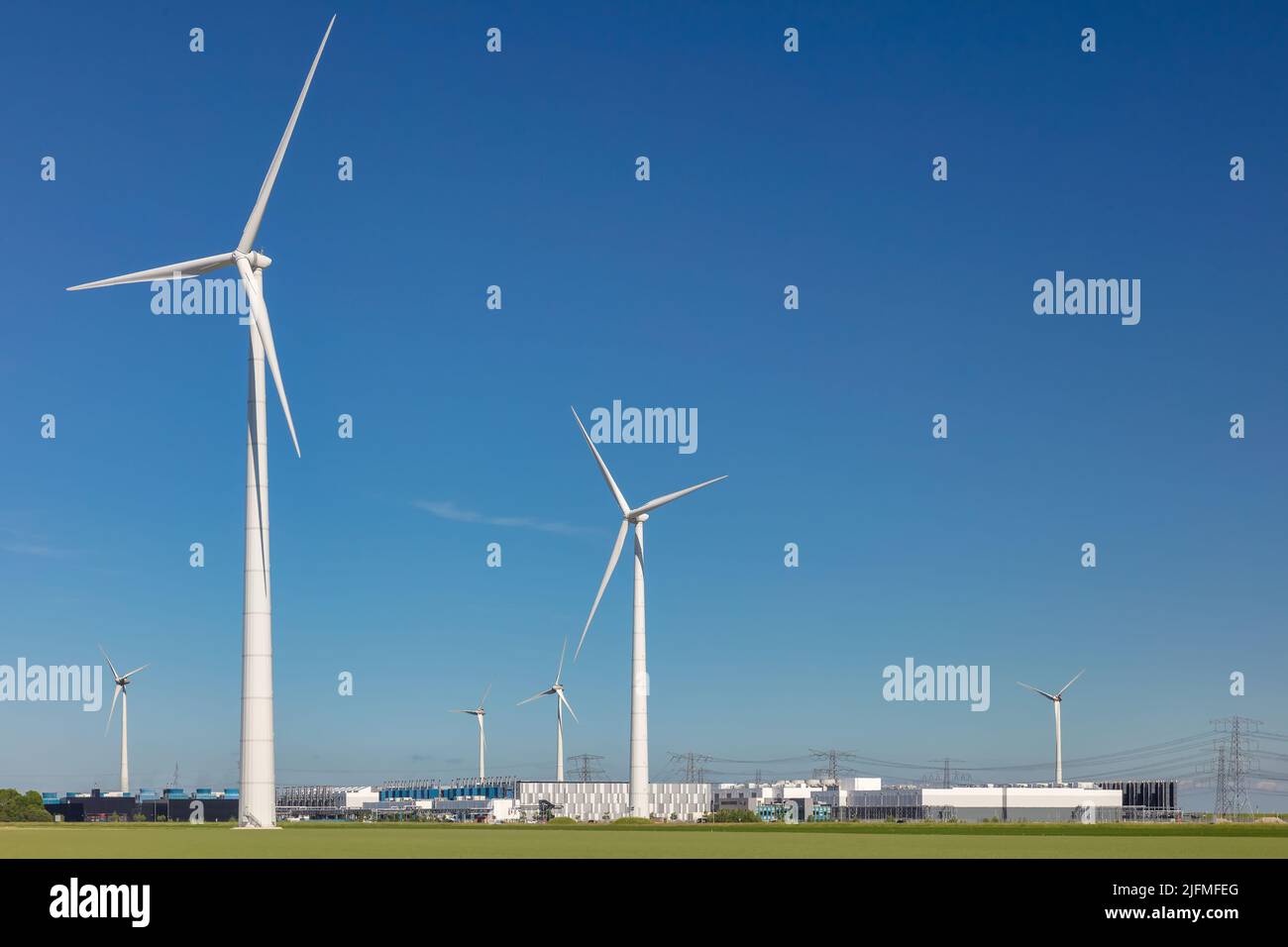 Eemshaven, Paesi Bassi - 2 giugno 2022: Visualizzazione in un data center Google con turbine eoliche circostanti di fronte a un cielo azzurro a Eemshaven Foto Stock