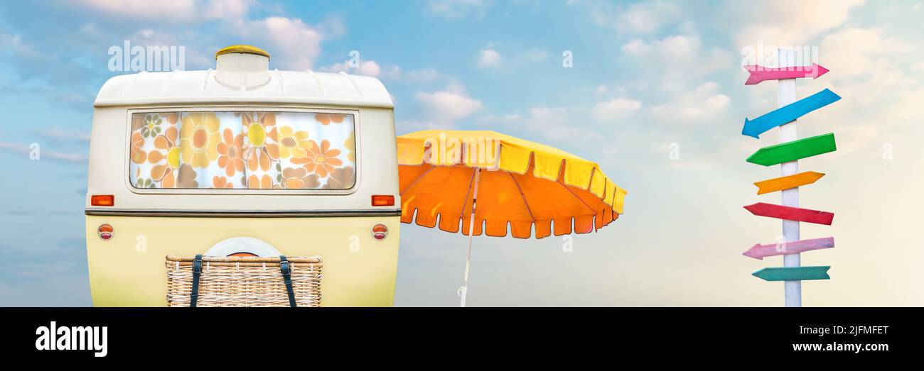 Caravan retrò con ombrello da spiaggia e colorato cartello in legno Foto Stock
