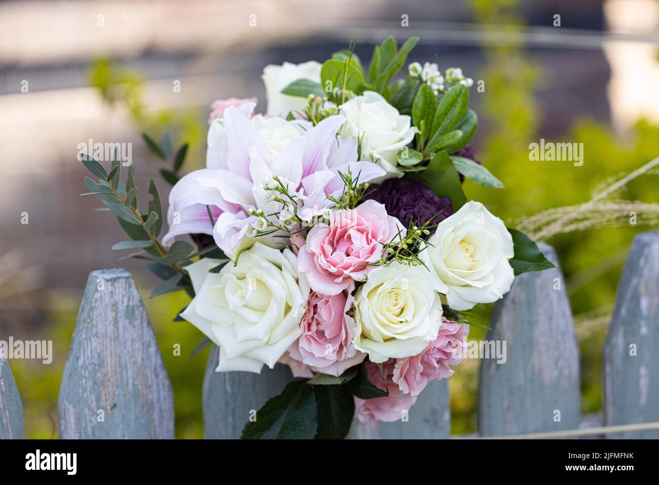 Un bouquet di fiori colorati su una recinzione di legno Foto Stock