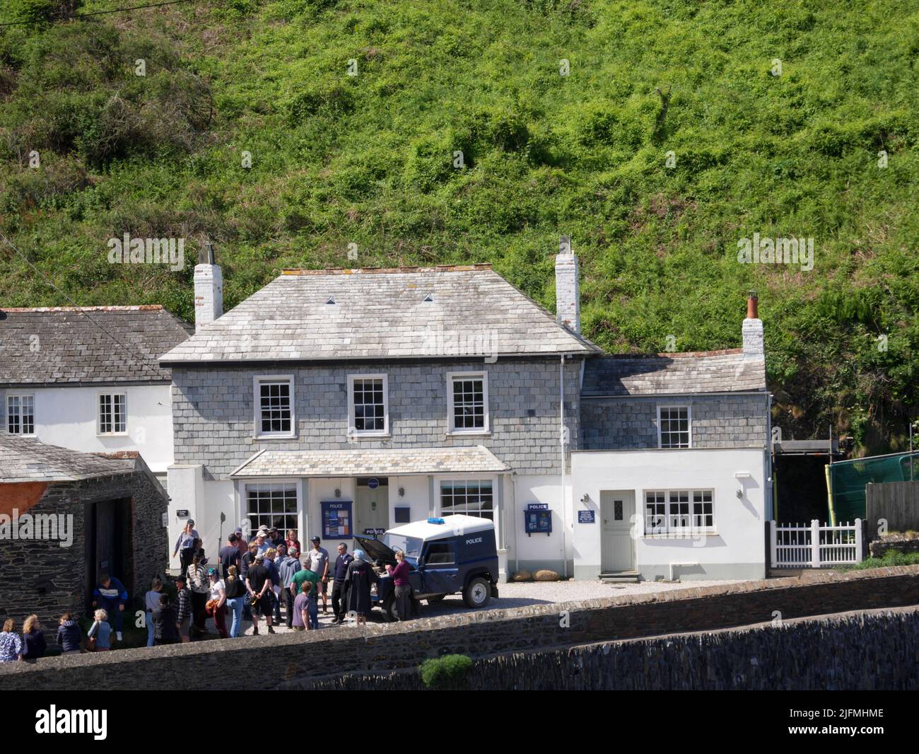 Filmare una scena della serie finale di Doc Martin a Port Gaverne. (John Marquez come P.C. Joseph Penhale). Foto Stock