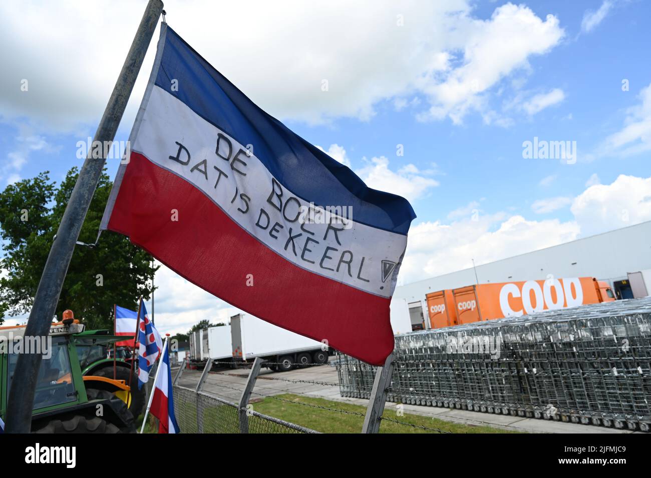 Gieten, Paesi Bassi. 04th luglio 2022. "Il dat di Boer è de Keerl!" ( L'agricoltore è l'uomo!) È scritto su una bandiera olandese di agricoltori che protestano. Per protestare contro le normative ambientali previste, gli agricoltori olandesi hanno bloccato i centri di distribuzione dei supermercati. Con i trattori e le balle di fieno hanno bloccato le strade di accesso in diversi punti del paese. Credit: Lars Klemmer/dpa/Alamy Live News Foto Stock