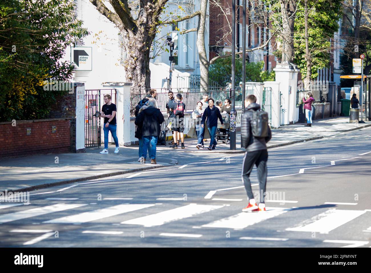 La gente si raduna intorno all'incrocio della zebra di fronte agli Abbey Road Studios di Londra. Foto Stock