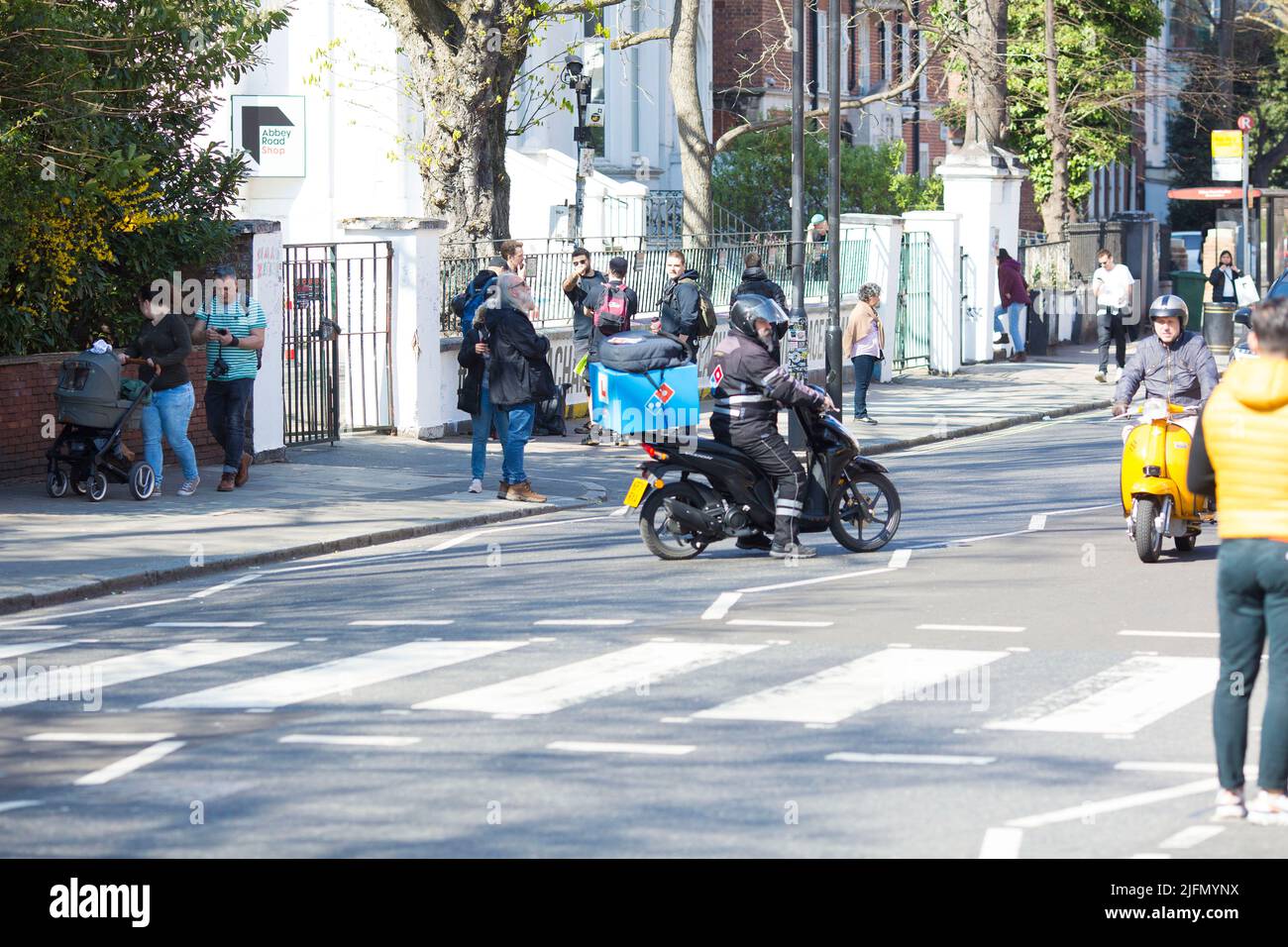 La gente si raduna intorno all'incrocio della zebra di fronte agli Abbey Road Studios di Londra. Foto Stock