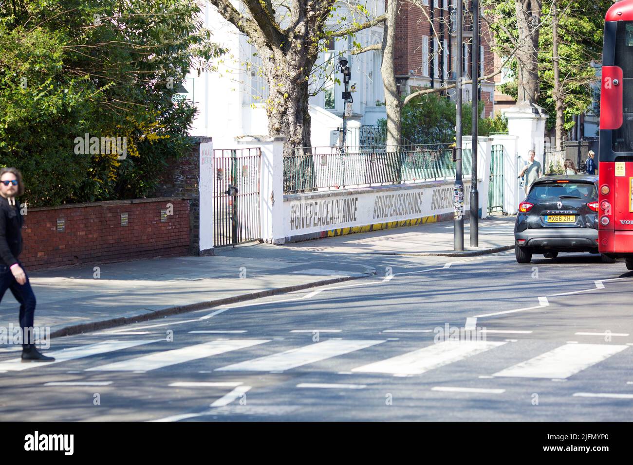 La gente si raduna intorno all'incrocio della zebra di fronte agli Abbey Road Studios di Londra. Foto Stock