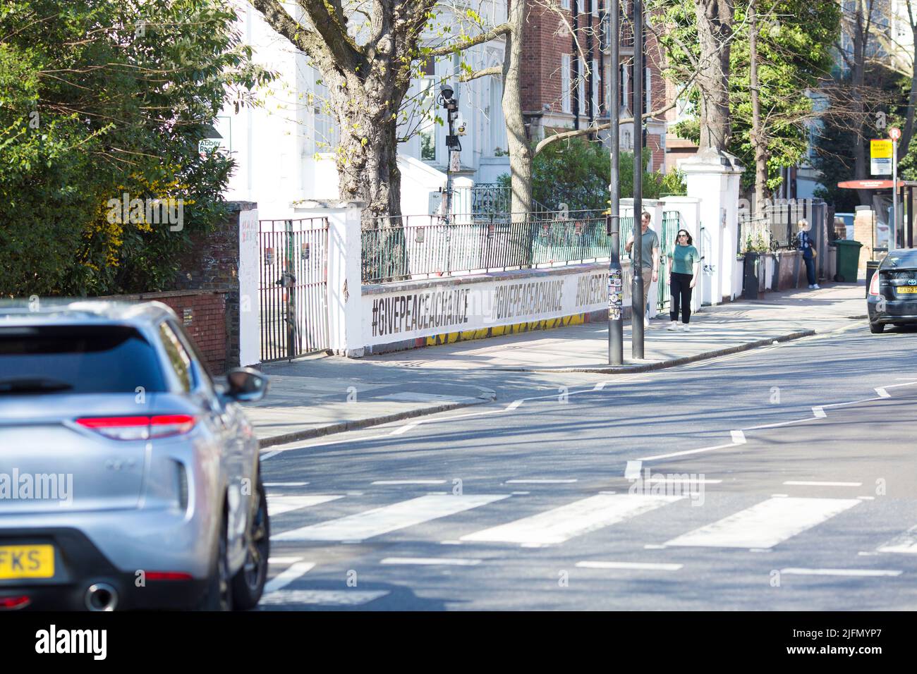 La gente si raduna intorno all'incrocio della zebra di fronte agli Abbey Road Studios di Londra. Foto Stock