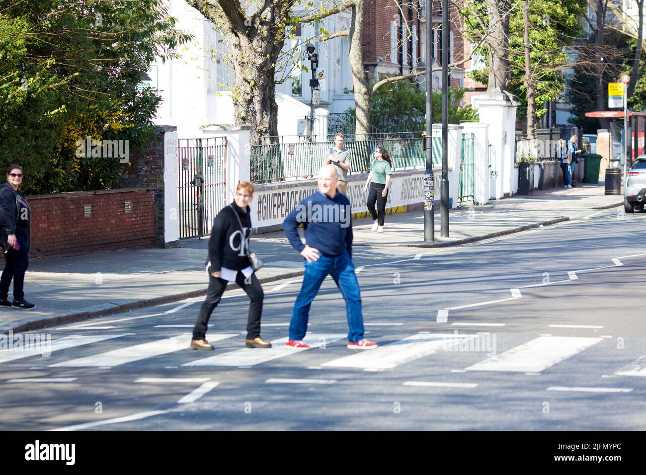 La gente si raduna intorno all'incrocio della zebra di fronte agli Abbey Road Studios di Londra. Foto Stock