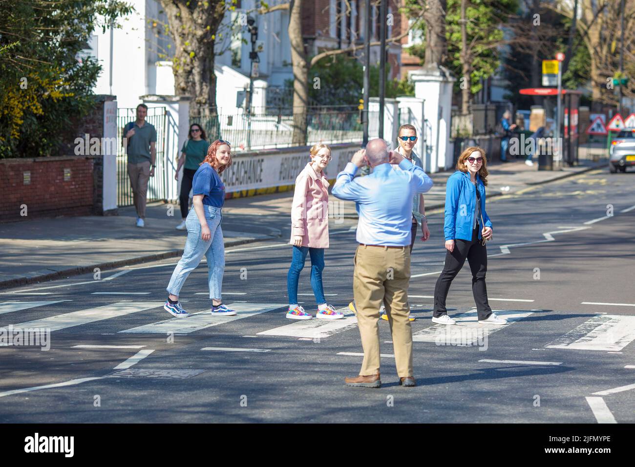 La gente si raduna intorno all'incrocio della zebra di fronte agli Abbey Road Studios di Londra. Foto Stock