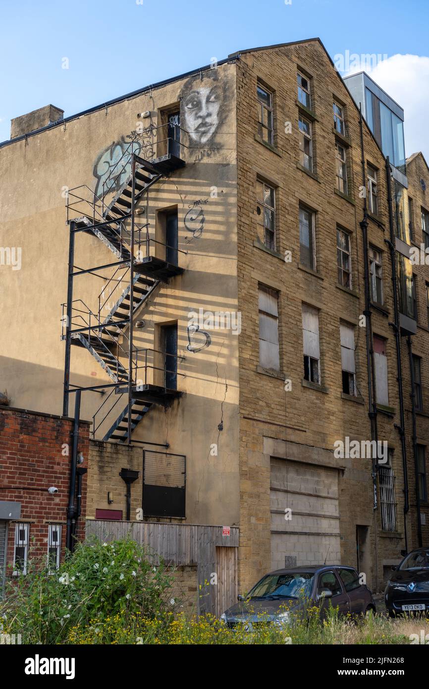 Una scala antincendio esterna sul lato di un edificio dismesso a più piani a Little Germany, nella città di Bradford, Regno Unito. Foto Stock