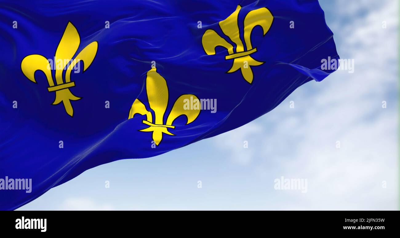 La bandiera della regione Ile de France ondeggiante nel vento in una giornata limpida. L'Ile de France è la più popolosa delle diciotto regioni della Francia Foto Stock