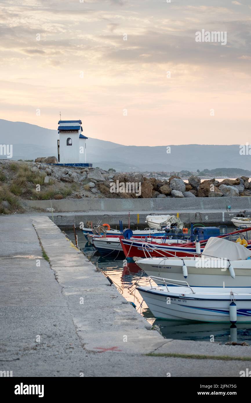 Scena di mare con barche da pesca e una piccola cappella sullo sfondo Foto Stock