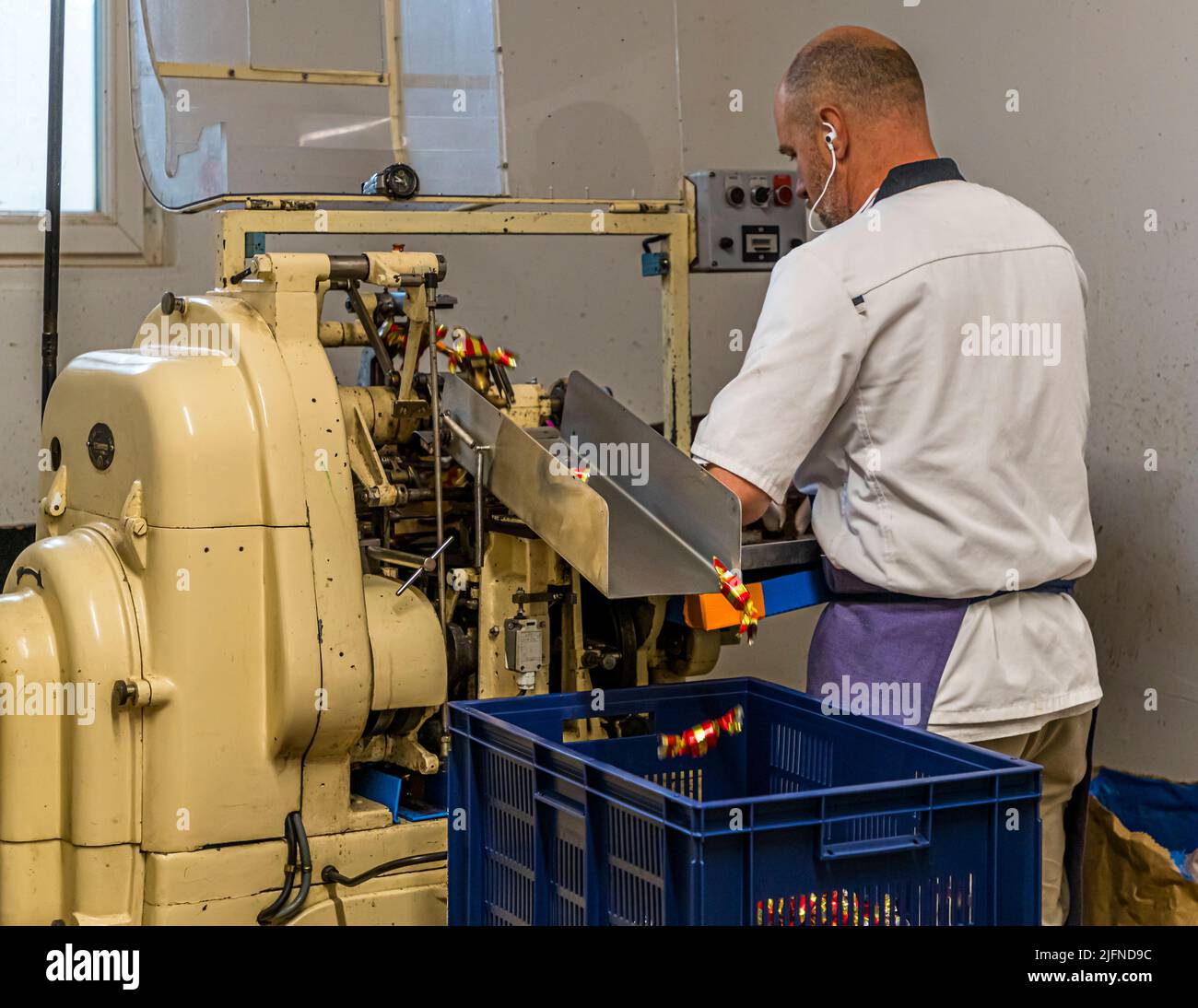 Confezionamento a macchina di cioccolatini al nocciola in oro e papillote rosse irrigidite alla Chocolaterie Frigoulette di Beaufort-sur-Gervanne in Val de Drôme Foto Stock