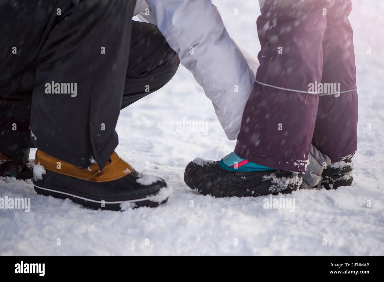 Scarpe invernali nella neve. Primo piano delle scarpe invernali. Scarpe impermeabili per bambini per camminare sulla neve. Temperature basse e caduta della neve Foto Stock