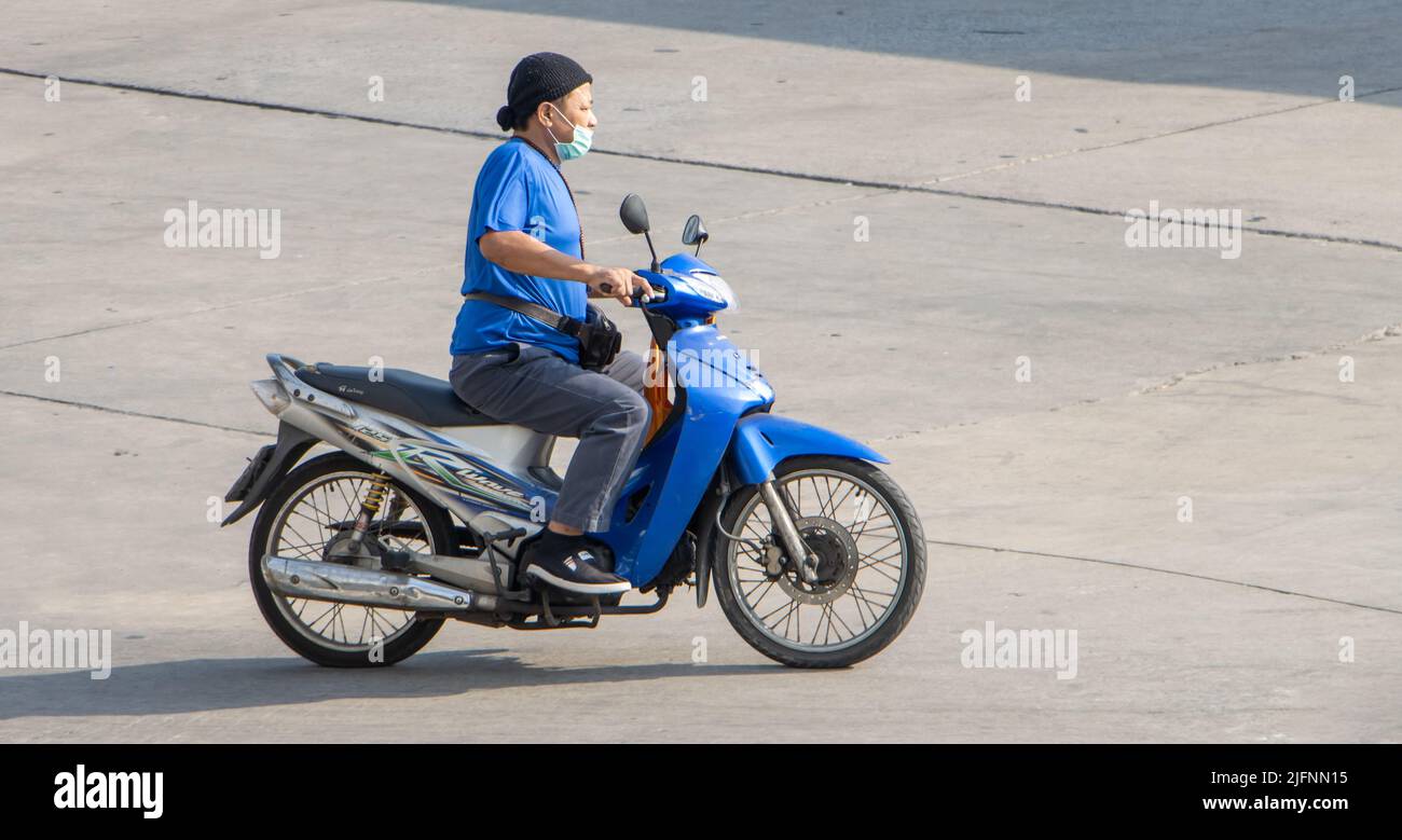 SAMUT PRAKAN, THAILANDIA, Apr 15 2022, un uomo con maschera di faccia corre una moto sulla strada Foto Stock