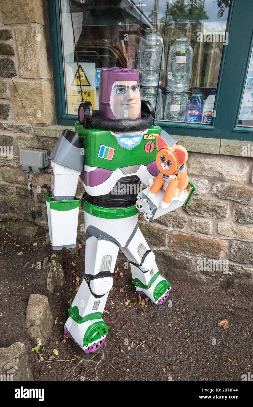 Fantastica costruzione di Buzz Lightyear e del suo gatto robot Sox al Settle Flowerpot Festival 2022, Yorkshire Dales National Park, North Yorkshire. Foto Stock