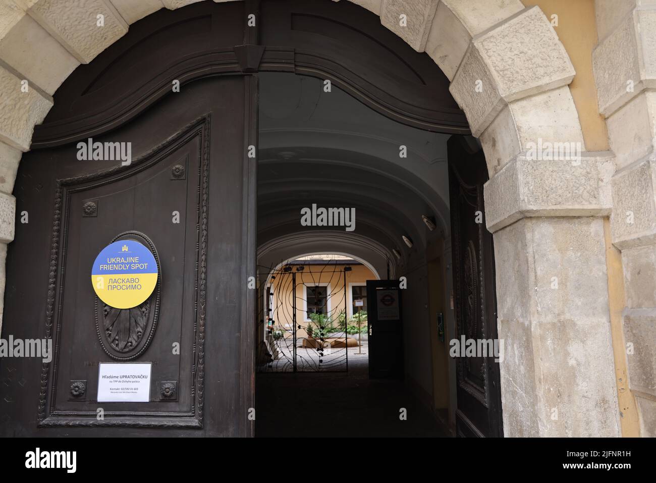 Porte con cartello giallo-blu con il testo "luogo amichevole ucraino - Ласкаво просимо", che indica che i rifugiati ucraini sono i benvenuti in questo luogo Foto Stock