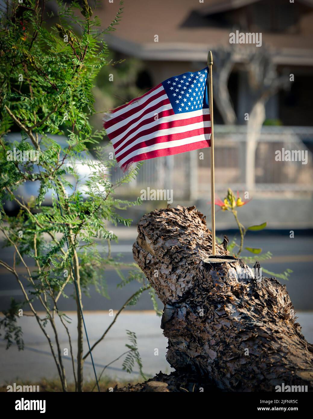 Una bandiera americana siede in un ceppo, soffia nel vento, nel quartiere di Five Points di El Paso, Texas. Foto Stock
