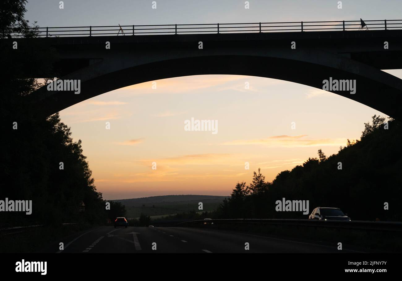 Tramonto sotto un ponte stradale Foto Stock